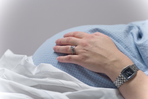 woman's hand over her pregnant stomach
