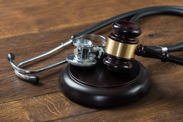 Closeup of gavel and stethoscope on table in courtroom