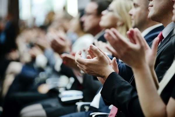 professionals clapping at a conference