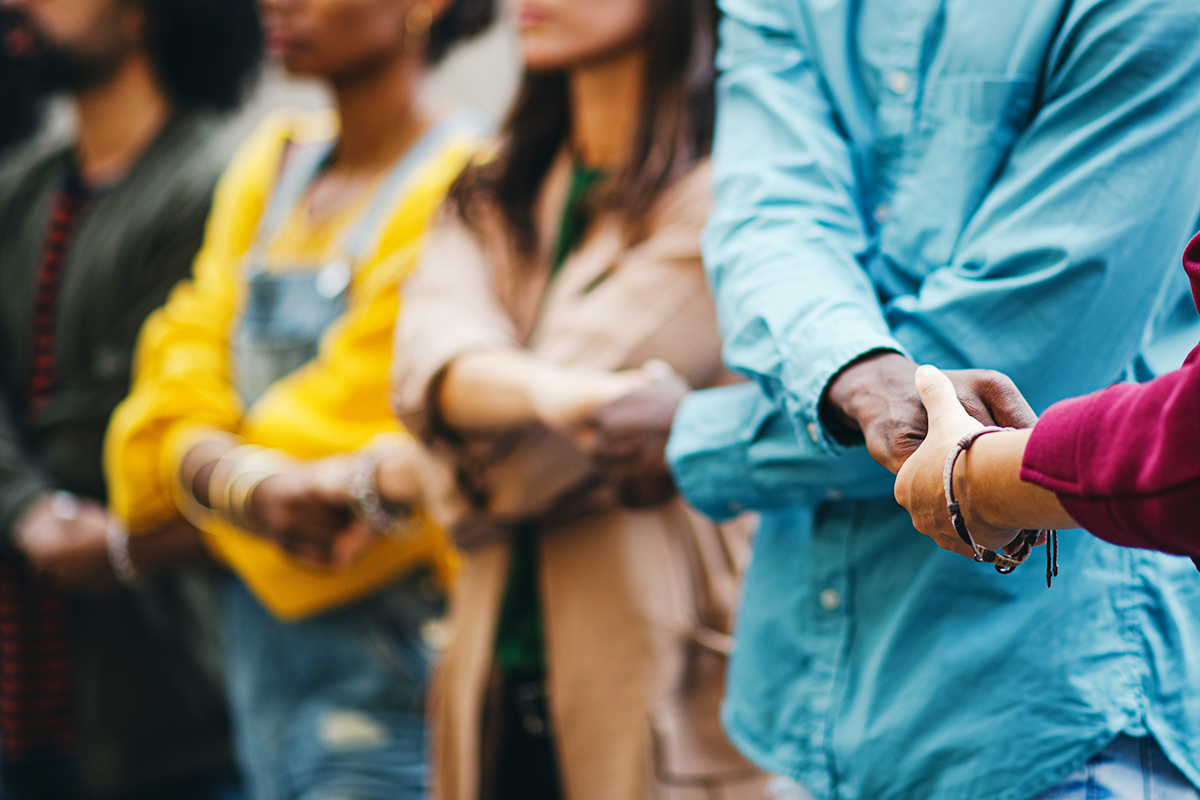 individuals of different races and genders link hands in support of civil rights