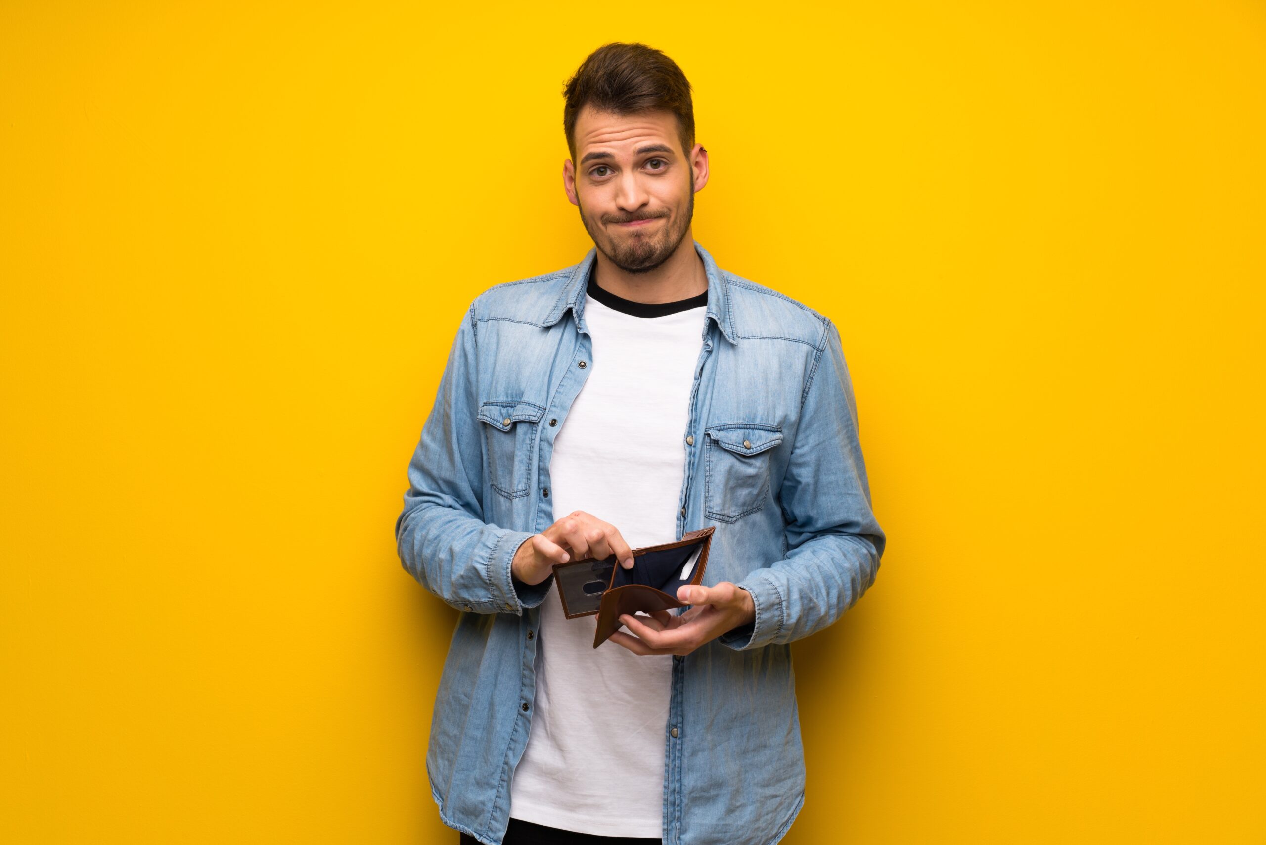 Single man standing alone, holding open, empty wallet