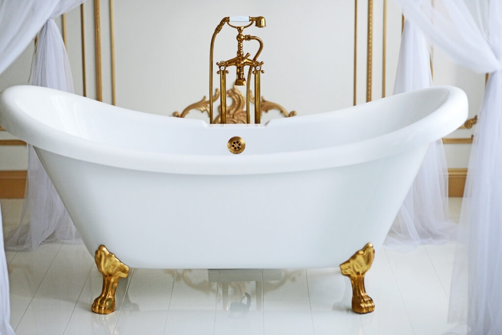 white clawfoot tub with gold fixtures and feet. 