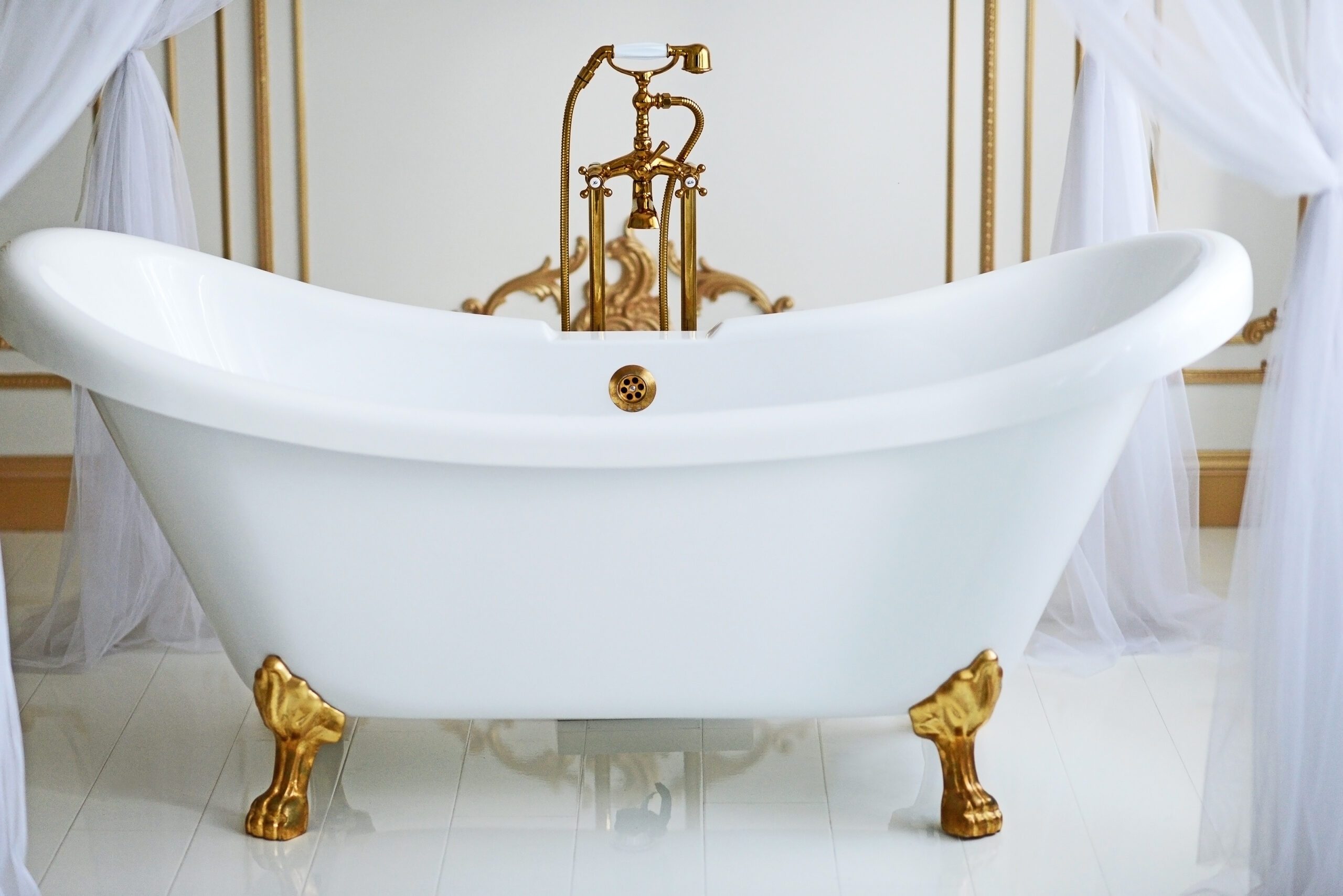 white clawfoot tub with gold fixtures and feet.