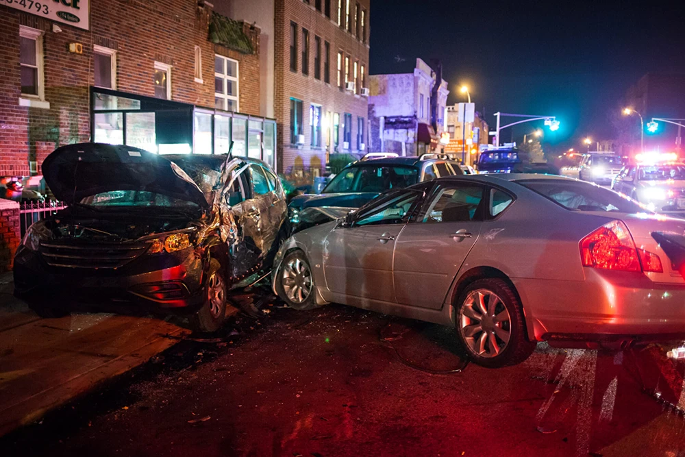 The aftermath of a multi-vehicle accident that had occurred near a city intersection at night.