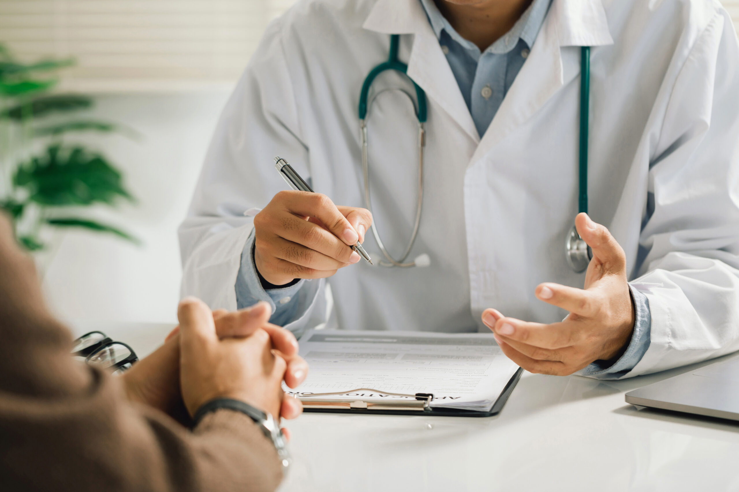 Doctor sitting down with patient in his office.