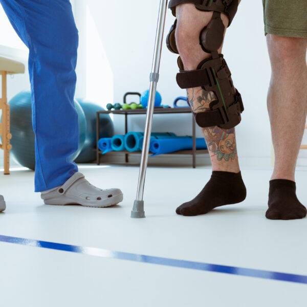 A patient with crutches with a physical therapist.