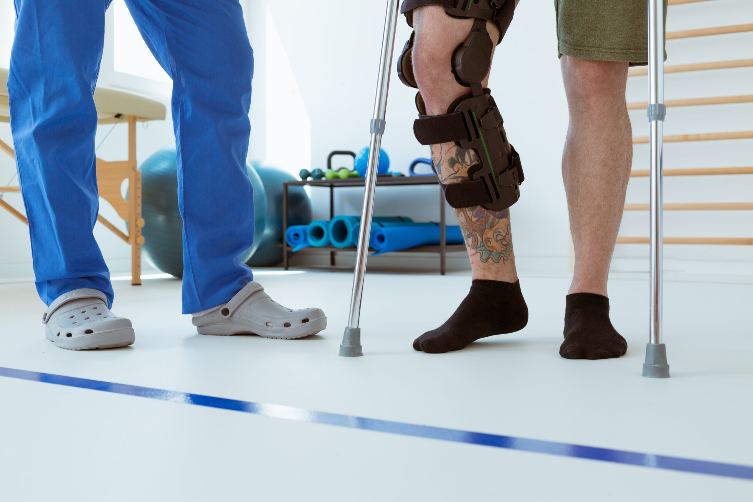 A patient with crutches with a physical therapist.