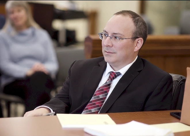 Timothy Cronin sitting at a desk in the court room