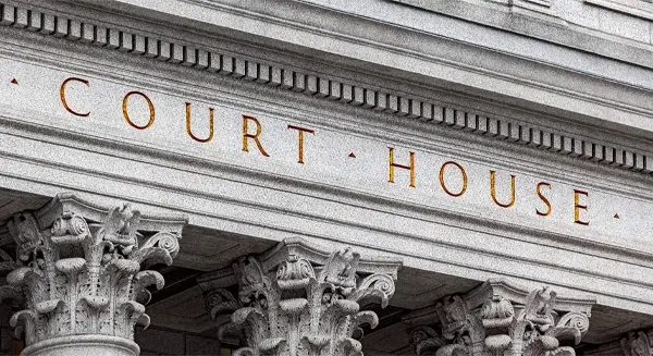 Close up of the words "court house" on a government building with columns.