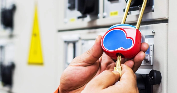 close up of a hand locking a machine with a key.