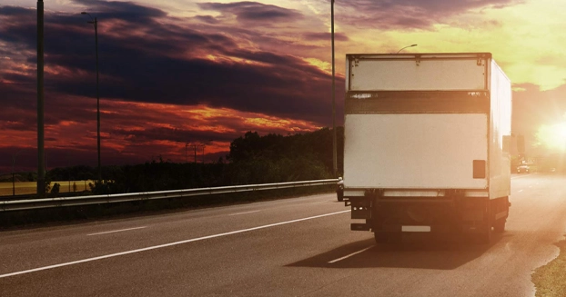 u-haul driving on a highway at sunset.