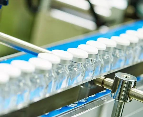 A bunch of drug containers on a conveyor belt.