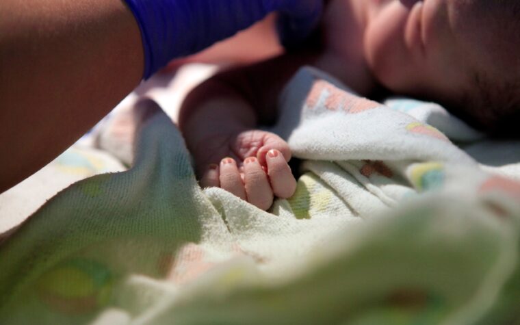 newborn baby being examined by a physician in the delivery room.