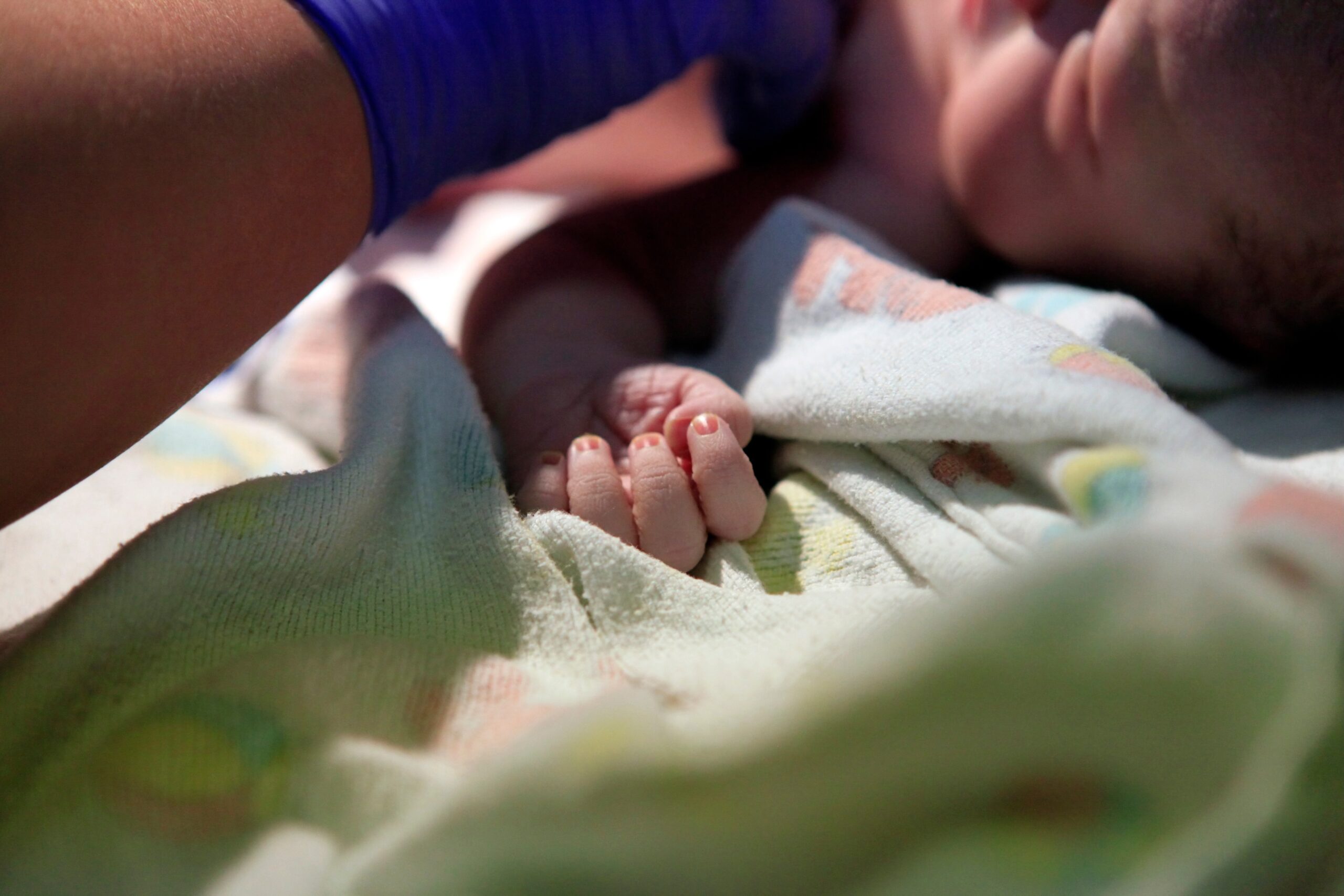 newborn baby being examined by a physician in the delivery room.