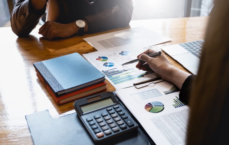 Business woman and partner discuss fiduciary responsibilities including budget plan, tax, accounting, statistics and analytic research.