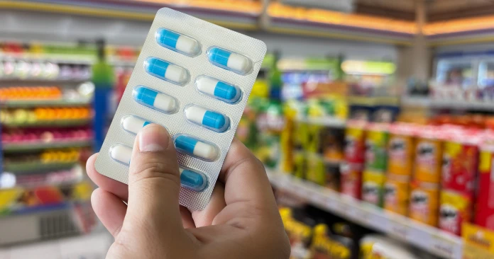 Person holding up medications purchased from a convenience store.